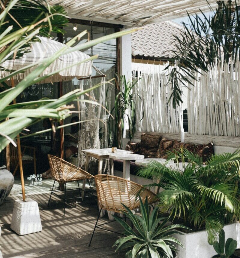 White table with brown wicker chair beside plants photo